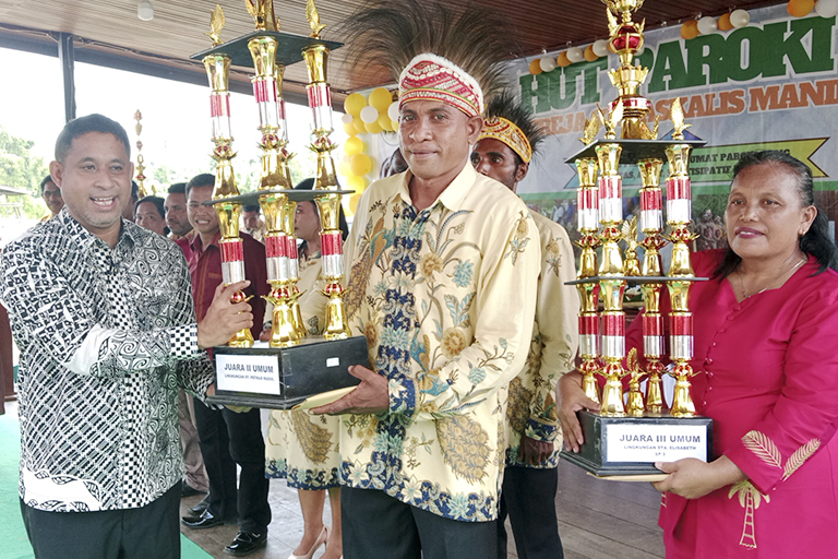 Bupati TB Yohanis Manibuy Menyerahkan Piala dan Santunan kepada Juara Umum Kedua dalam Lomab-Lomba Jelang HUT Paroki