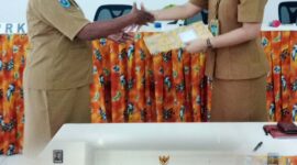 Sekretaris Distrik Bintuni, Oktovina Manibuy mewakili Kepala Distrik  menyerahkan dokumen hasil Musrenbang Distrik Bintuni Kabupaten Teluk Bintuni kepada Kasubid Pelaporan, mewakili Kepala Bappelitbangda, Mariska Laukom