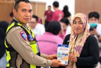Foto: Kasat Lantas Polres Teluk Bintuni AKP. Yusuf Manilet menyerahkan Celana kepada peserta Sunatan Massal/ Sumber: Istimewa & Tina